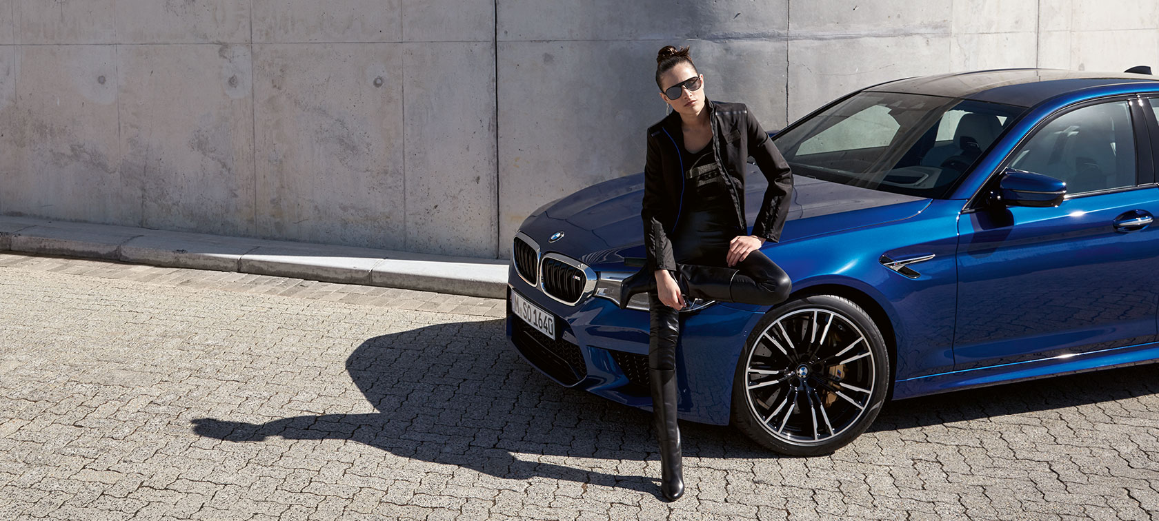 Vrouw in BMW M Collection met sweatjack en zonnebril. Vrouw in BMW M Collection met sweatjack en zonnebril.